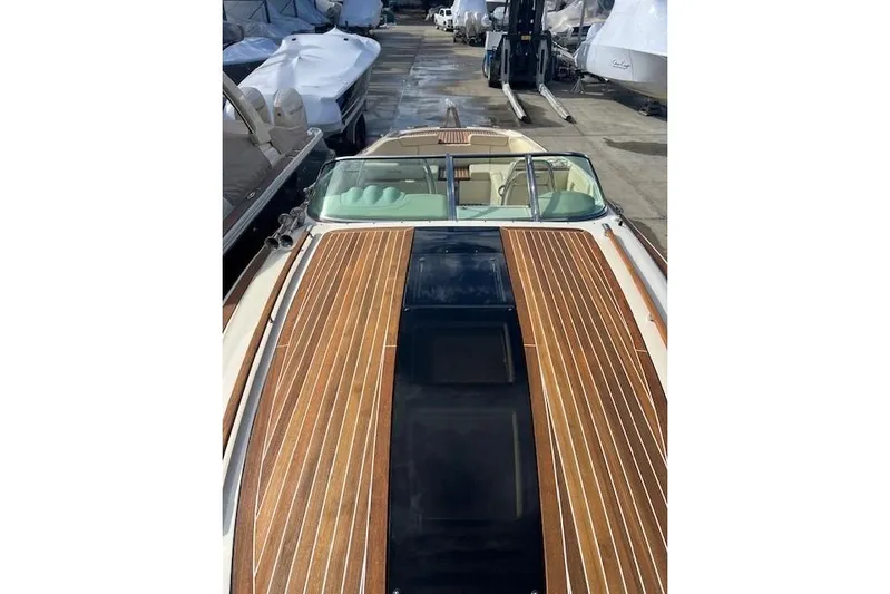  Yacht Photos Pics 2017 Chris-Craft Corsair 32 with sleek wooden deck, docked among other boats.