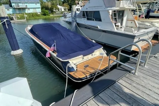  Yacht Photos Pics 2017 Chris-Craft Corsair 32 boat docked, covered with a blue tarp, American flag displayed.