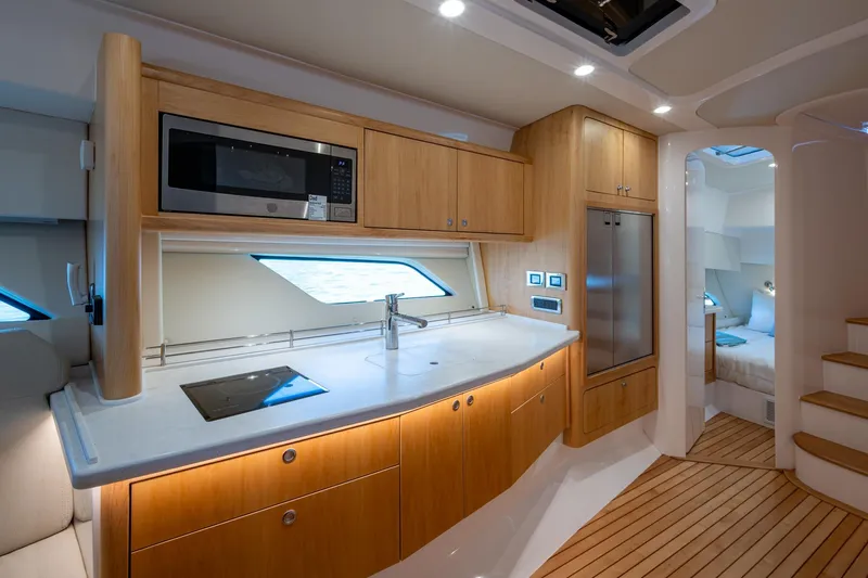 Rising Tide Yacht Photos Pics Luxurious 2023 Intrepid 477 Evolution yacht interior with modern kitchen and cozy bedroom.