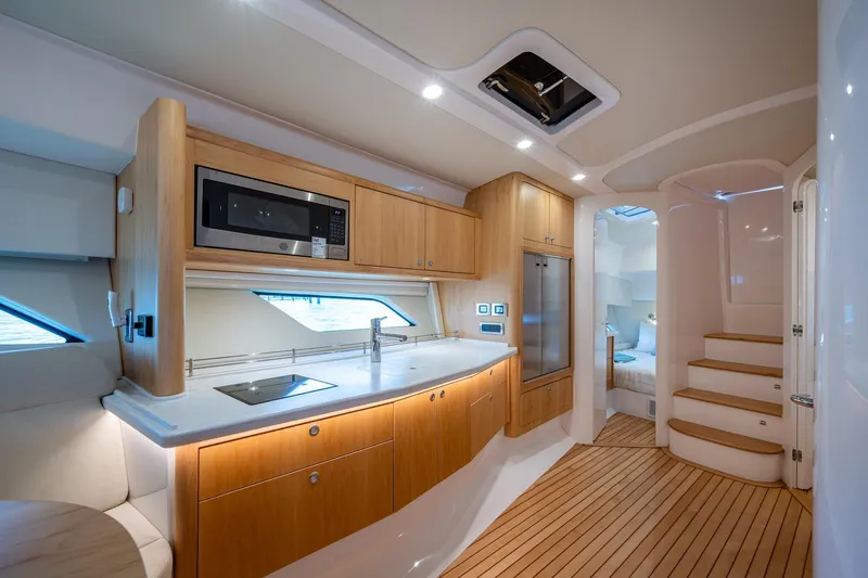 Rising Tide Yacht Photos Pics Luxurious interior of 2023 Intrepid 477 Evolution yacht with modern kitchen and cozy bedroom.
