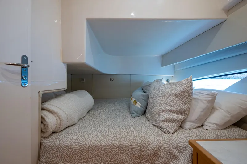 Rising Tide Yacht Photos Pics Cozy cabin interior of 2023 Intrepid 477 Evolution yacht with plush bedding and modern design.