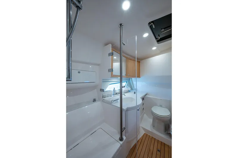 Rising Tide Yacht Photos Pics Luxurious bathroom interior of 2023 Intrepid 477 Evolution yacht, featuring modern fixtures and wooden accents.
