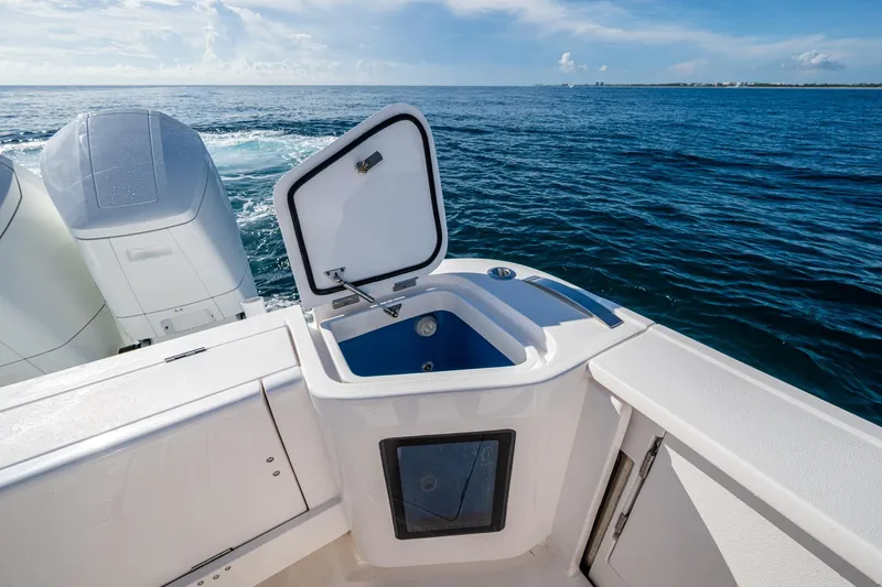 Rising Tide Yacht Photos Pics 2023 Intrepid 477 Evolution boat with open storage compartment, ocean view.