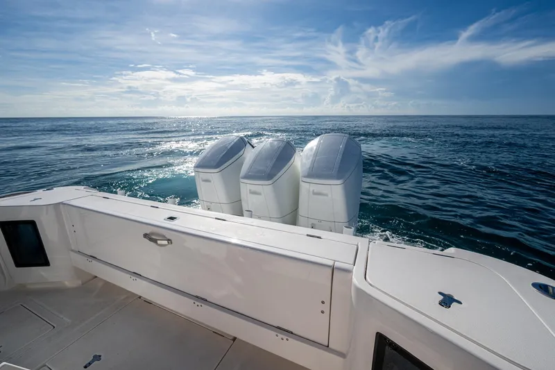 Rising Tide Yacht Photos Pics 2023 Intrepid 477 Evolution boat with triple outboard engines on open sea.