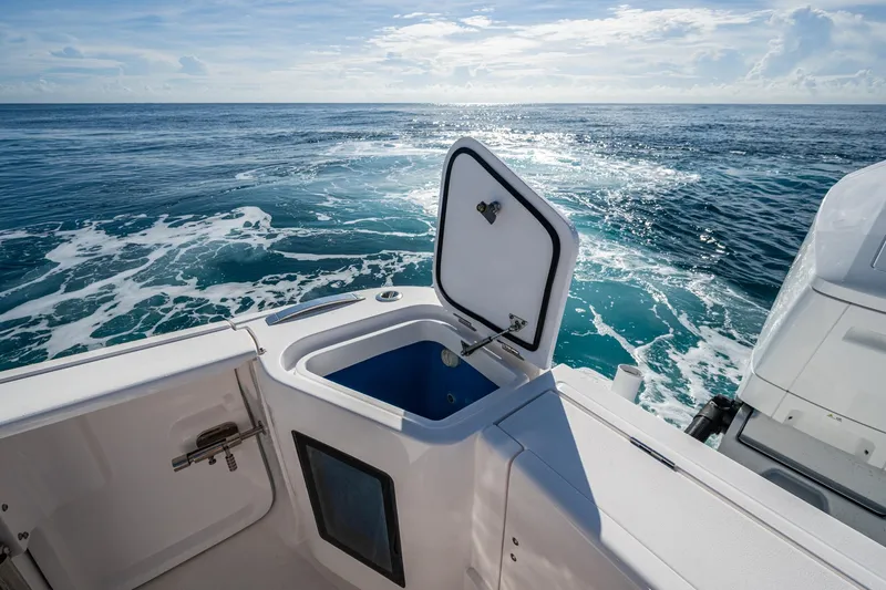 Rising Tide Yacht Photos Pics 2023 Intrepid 477 Evolution boat with open storage compartment, ocean view.
