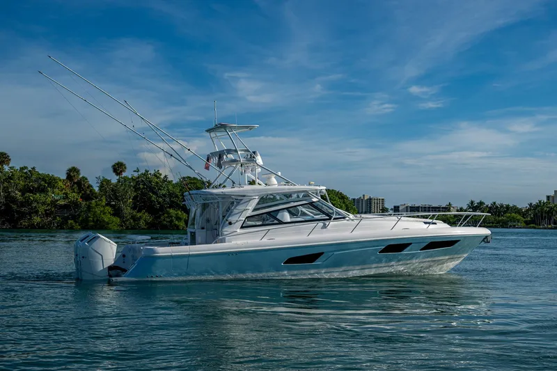 Rising Tide Yacht Photos Pics 2023 Intrepid 477 Evolution boat cruising on a serene waterway under a clear blue sky.
