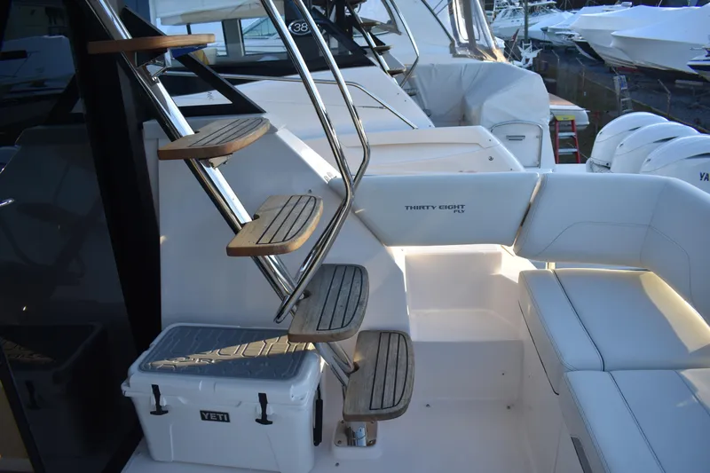  Yacht Photos Pics 2025 Regal 38 FXO yacht interior with wooden steps and cushioned seating.