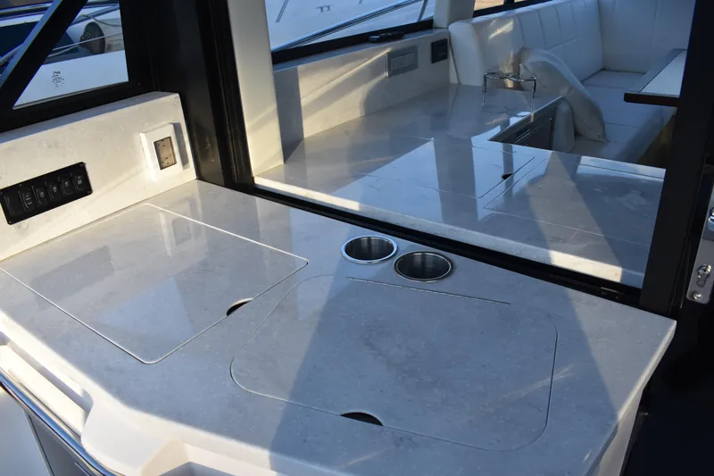  Yacht Photos Pics Luxurious interior of 2025 Regal 38 FXO yacht with sleek countertops and seating area.