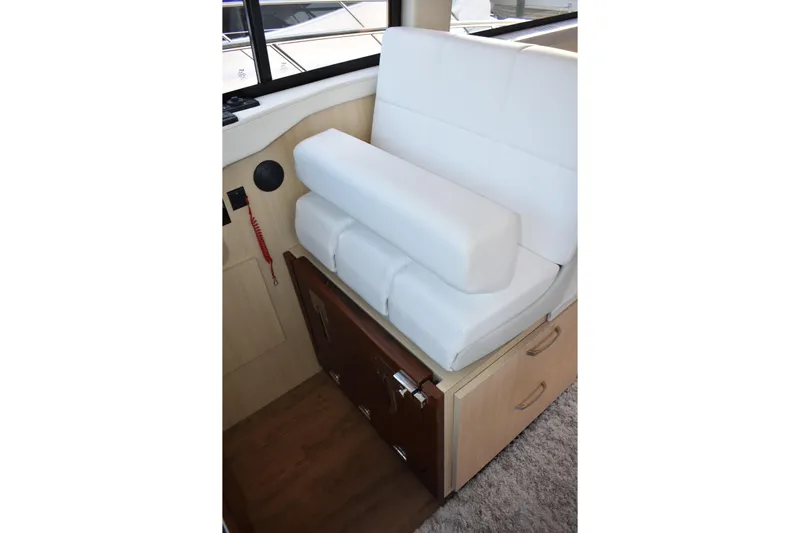  Yacht Photos Pics 2025 Regal 38 FXO interior with white cushioned seating and wooden storage.