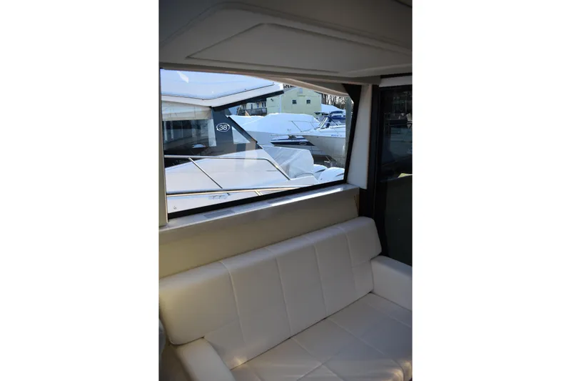  Yacht Photos Pics Interior view of 2025 Regal 38 FXO yacht with white seating and window.