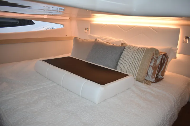  Yacht Photos Pics Luxurious cabin interior of 2025 Regal 38 FXO yacht with elegant bedding and ambient lighting.