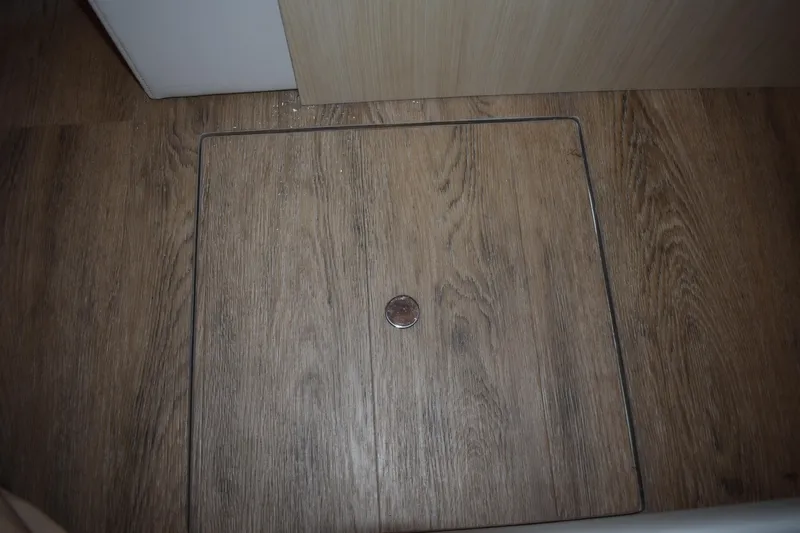  Yacht Photos Pics Wooden floor panel with a coin, inside a 2025 Regal 38 FXO boat.