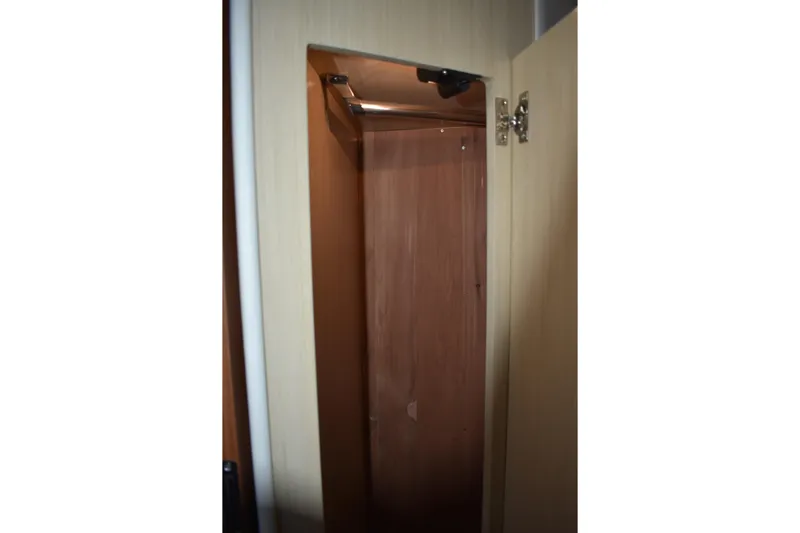  Yacht Photos Pics Interior closet of 2025 Regal 38 FXO yacht, featuring wooden finish and open door.