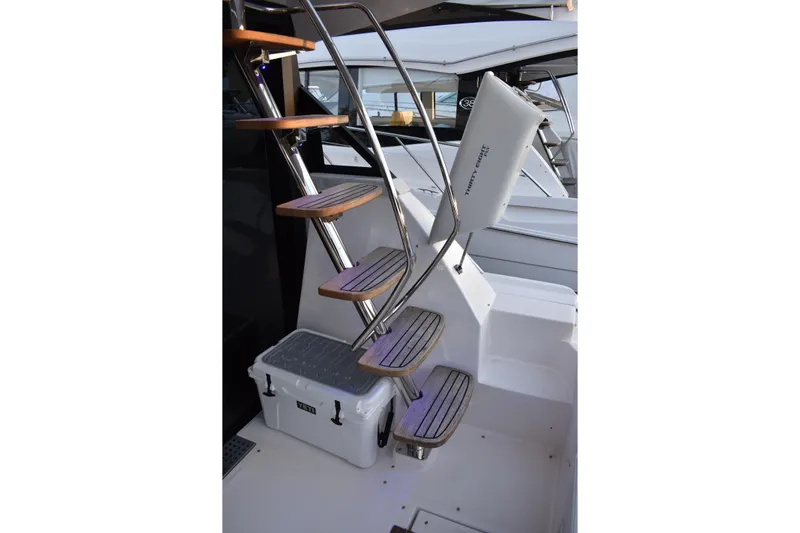  Yacht Photos Pics Staircase on 2025 Regal 38 FXO yacht with wooden steps and a cooler below.