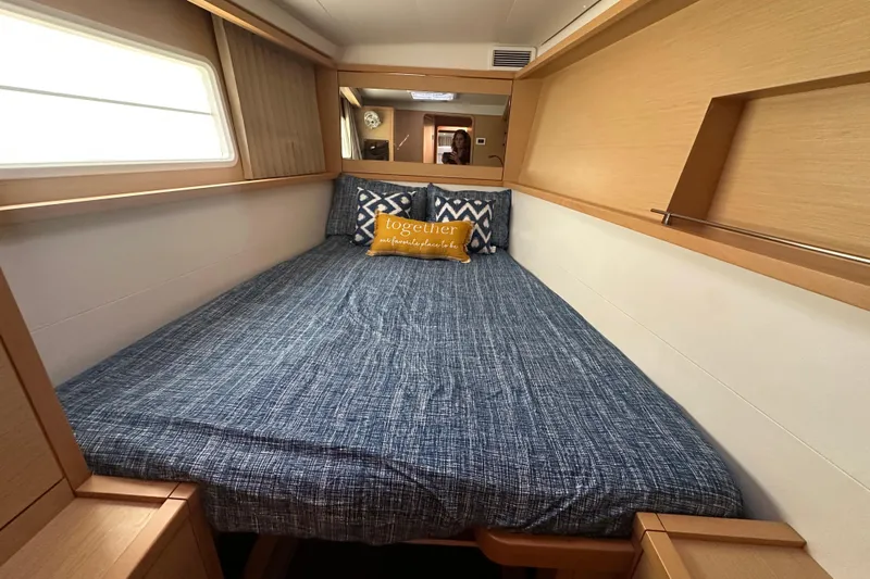 Callisto Yacht Photos Pics Cozy bedroom interior of 2014 Lagoon 450 F yacht with blue bedding and decorative pillows.