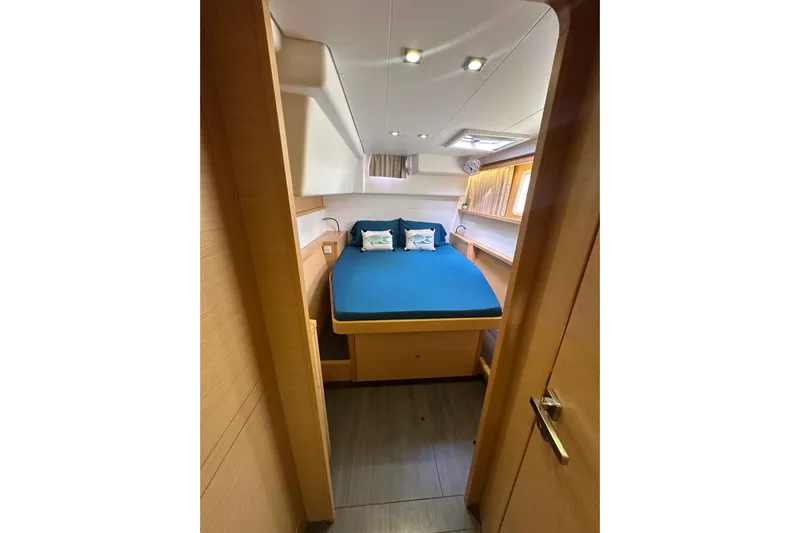 Callisto Yacht Photos Pics Cozy cabin interior of 2014 Lagoon 450 F catamaran with blue bedding.