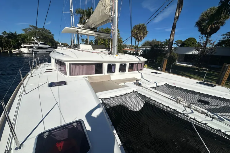 Callisto Yacht Photos Pics 2014 Lagoon 450 F catamaran docked, showcasing spacious deck and sails under clear blue sky.