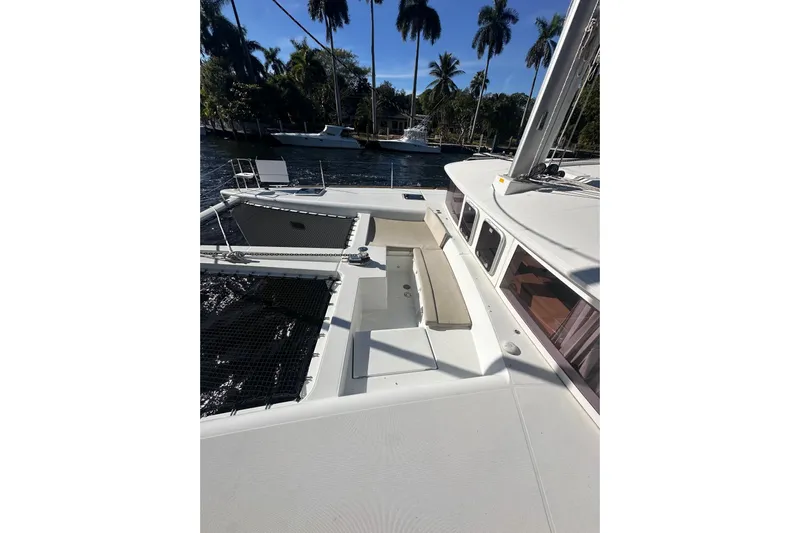 Callisto Yacht Photos Pics 2014 Lagoon 450 F catamaran deck with seating, docked near palm trees.