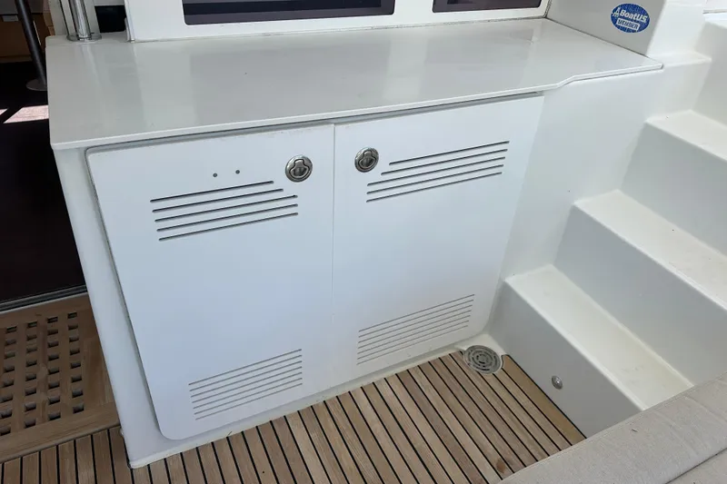 Callisto Yacht Photos Pics White storage cabinet on Lagoon 450 F yacht, 2014 model, with teak flooring and steps.