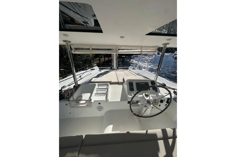 Callisto Yacht Photos Pics Lagoon 450 F 2014 catamaran helm with steering wheel, navigation controls, and sunlit deck.
