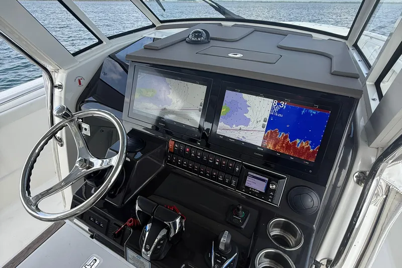 Oorah Yacht Photos Pics 2022 Pursuit S 378 Sport boat dashboard with navigation screens and steering wheel.