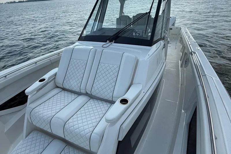 Oorah Yacht Photos Pics 2022 Pursuit S 378 Sport boat with luxurious white seating on calm water.