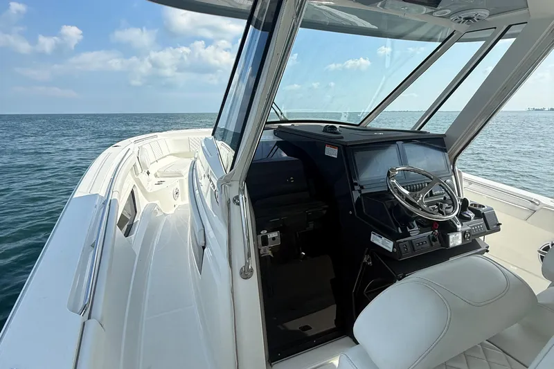 Oorah Yacht Photos Pics 2022 Pursuit S 378 Sport boat interior with helm, ocean view, and clear skies.