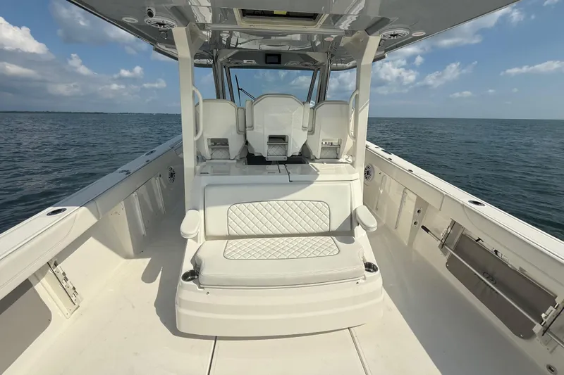 Oorah Yacht Photos Pics 2022 Pursuit S 378 Sport boat interior with seating, on open water under blue sky.