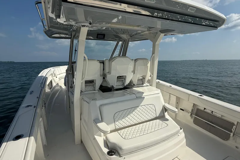 Oorah Yacht Photos Pics 2022 Pursuit S 378 Sport boat interior with seating, on calm ocean waters.