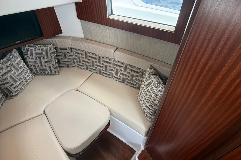 Oorah Yacht Photos Pics 2022 Pursuit S 378 Sport cabin interior with cushioned seating and patterned pillows.