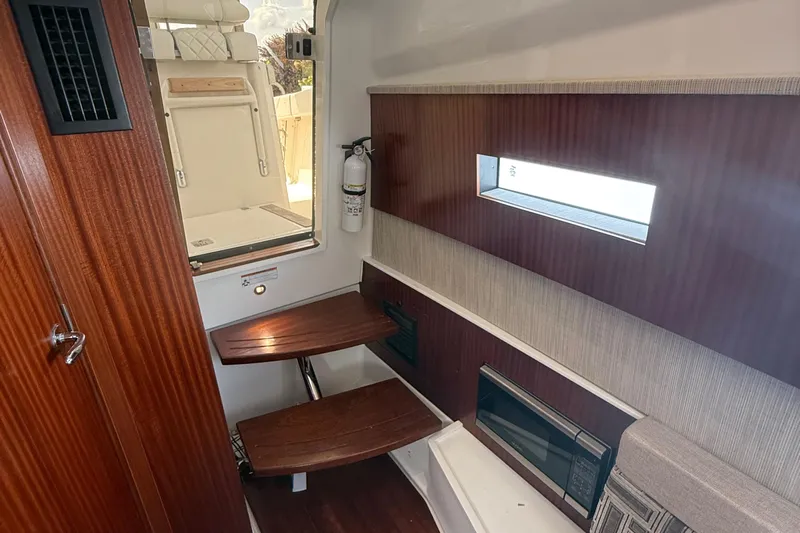 Oorah Yacht Photos Pics 2022 Pursuit S 378 Sport cabin interior with wooden accents and seating.