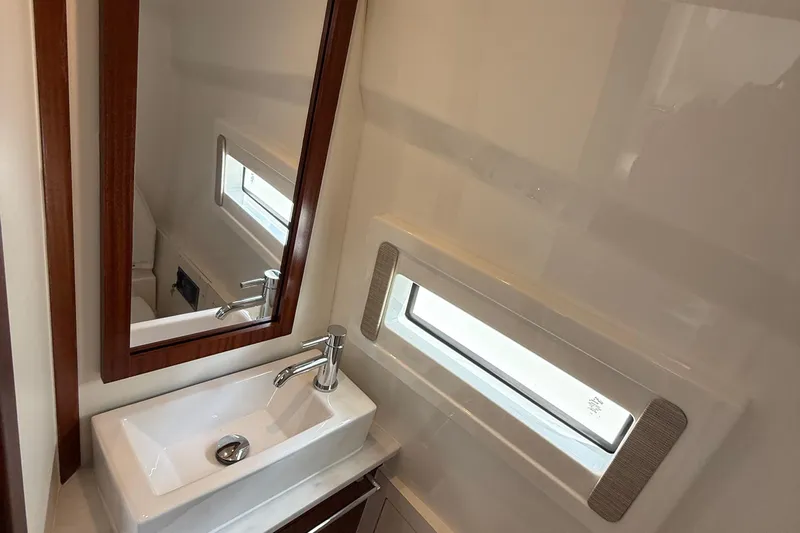 Oorah Yacht Photos Pics 2022 Pursuit S 378 Sport boat bathroom with modern sink, mirror, and window.