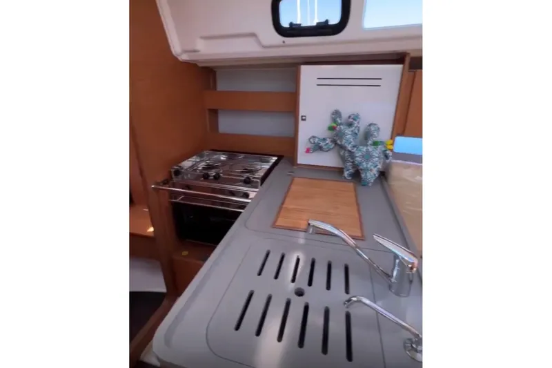  Yacht Photos Pics 2023 Dufour 32 yacht kitchen with stove, sink, and decorative item.