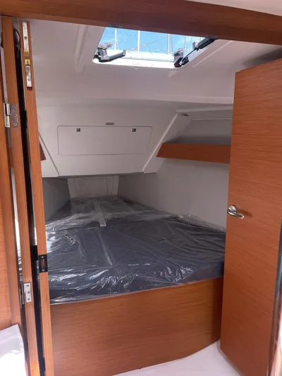  Yacht Photos Pics 2023 Dufour 32 yacht cabin with wooden interior and skylight.