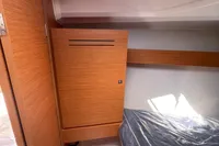 2023 Dufour 32 yacht interior cabin with wooden cabinetry and bed.