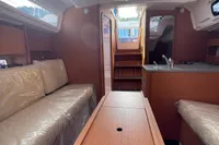 2023 Dufour 32 yacht interior with cozy seating and modern kitchen area.