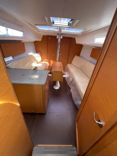  Yacht Photos Pics Interior of 2023 Dufour 32 sailboat with modern wood finish and seating area.