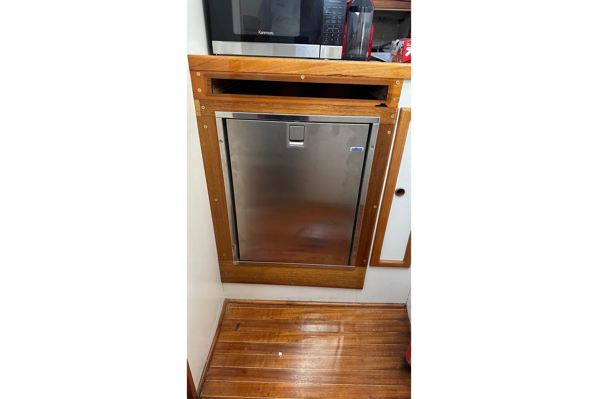 1982 Jarvis Newman Flybridge Cruiser interior with stainless steel fridge and wooden cabinetry.