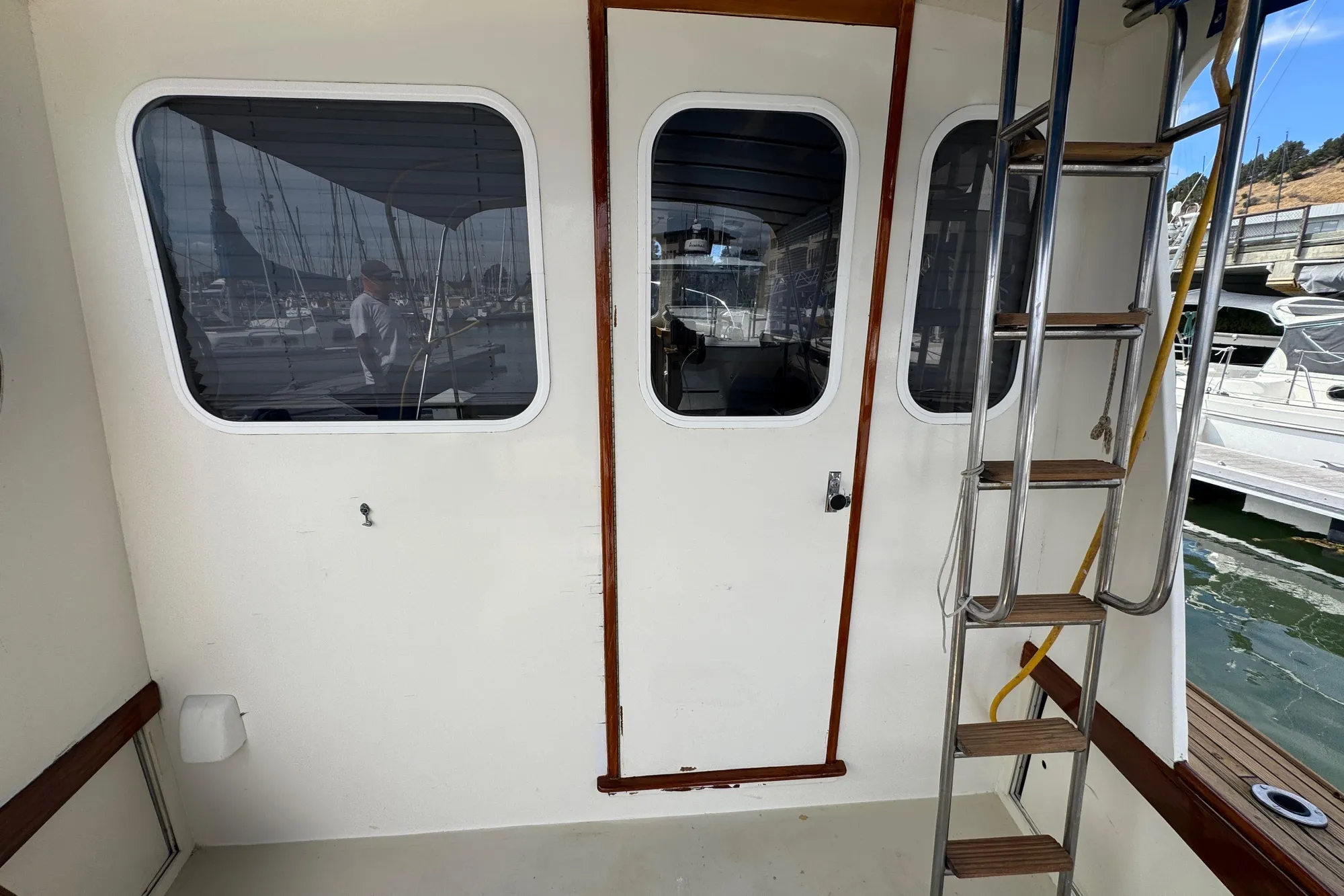 1982 Jarvis Newman Flybridge Cruiser with ladder and cabin door at marina.