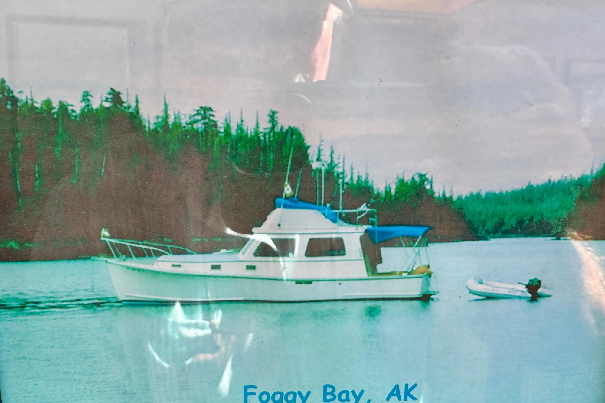 1982 Jarvis Newman Flybridge Cruiser in Foggy Bay, Alaska, surrounded by lush forest.