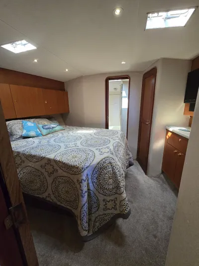  Yacht Photos Pics Cozy bedroom in 1999 Ocean Yachts 48 Super Sport with patterned bedding and wooden cabinetry.