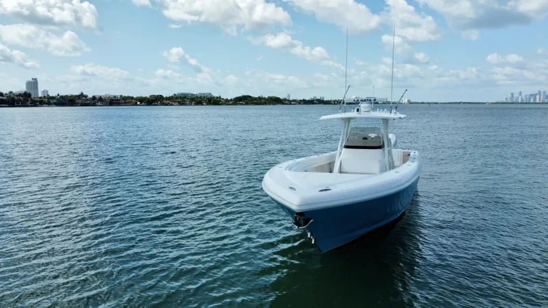 La Nata 3 Yacht Photos Pics 2015 Intrepid 375 Center Console boat on calm water under a partly cloudy sky.