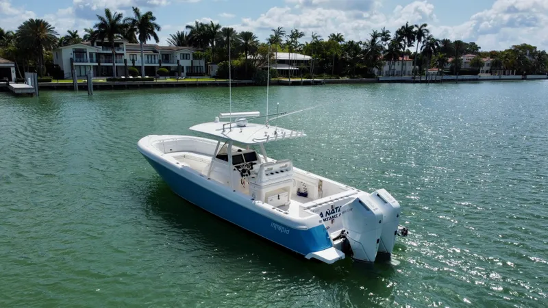 La Nata 3 Yacht Photos Pics 2015 Intrepid 375 Center Console boat on calm water near luxury waterfront homes.