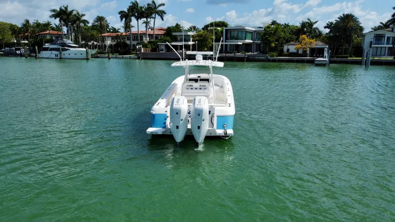 La Nata 3 Yacht Photos Pics 2015 Intrepid 375 Center Console boat on calm water, with waterfront homes in the background.