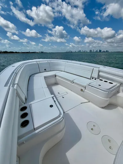 La Nata 3 Yacht Photos Pics 2015 Intrepid 375 Center Console boat with spacious seating, on calm waters under a partly cloudy sky.