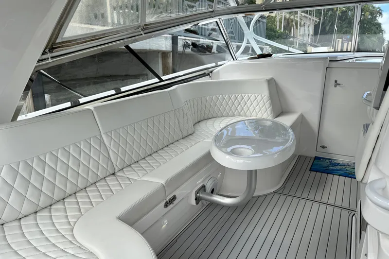 Tekeze Yacht Photos Pics Luxurious interior of 2019 Intrepid 475 Sport Yacht with white quilted seating and sleek table.