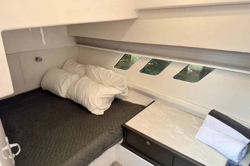 Tekeze Yacht Photos Pics Cozy cabin interior of 2019 Intrepid 475 Sport Yacht with bed and porthole windows.