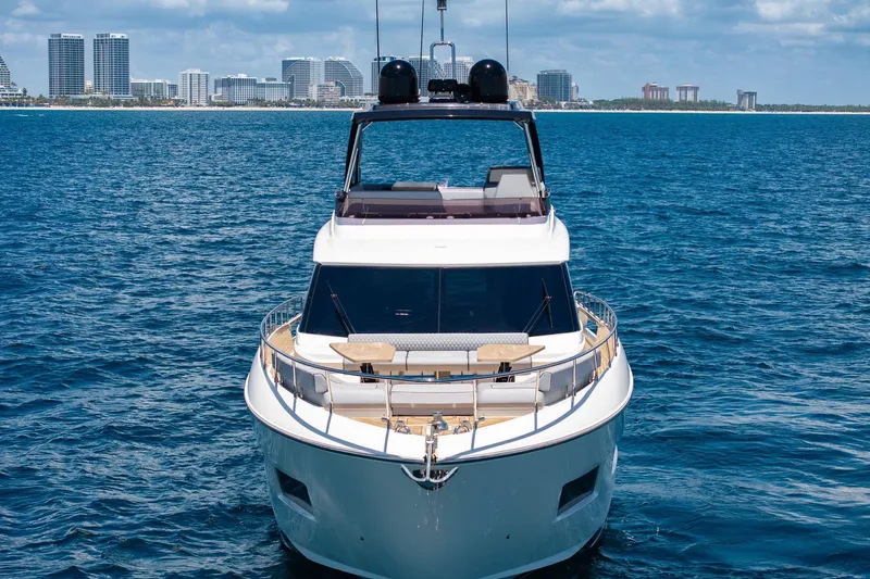  Yacht Photos Pics 2022 Ferretti Yachts 670 on open water with city skyline backdrop.