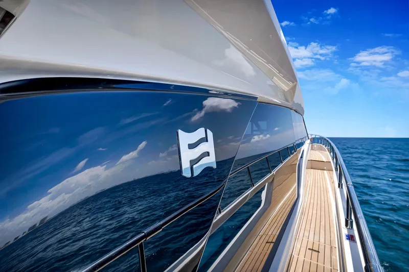  Yacht Photos Pics 2022 Ferretti Yachts 670 reflecting ocean and sky, sleek design, luxury yacht exterior.