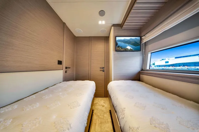  Yacht Photos Pics Luxurious twin bedroom in 2022 Ferretti Yachts 670, featuring modern design and scenic window view.